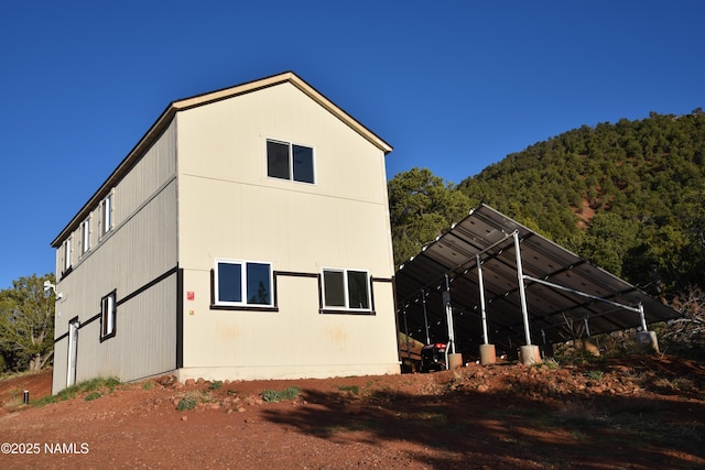 1026 E San Marcos Rd, Williams, AZ 86046 - view of side of home featuring a carport and a view of trees