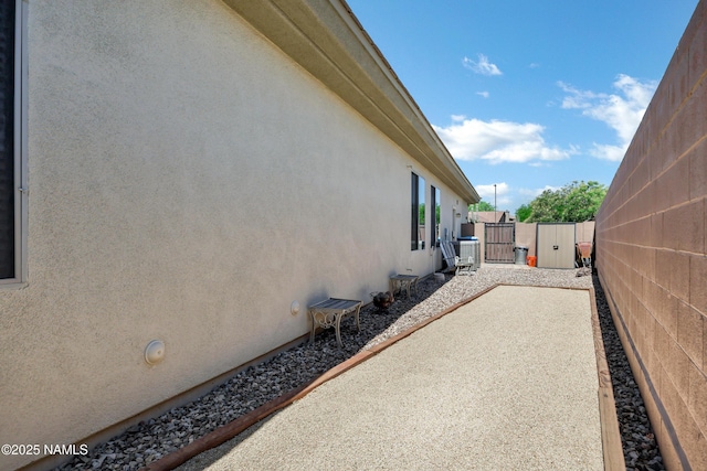 41215 N Lytham Ct, Phoenix, AZ 85086 - view of side of property featuring stucco siding, a gate, and a patio