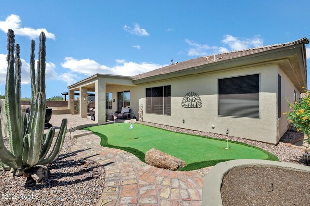 41215 N Lytham Ct, Phoenix, AZ 85086 - rear view of house featuring a putting area, a patio, and stucco siding