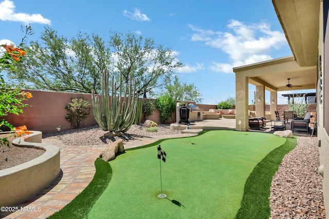 41215 N Lytham Ct, Phoenix, AZ 85086 - fenced backyard with a putting green, a patio, ceiling fan, and an outdoor living space