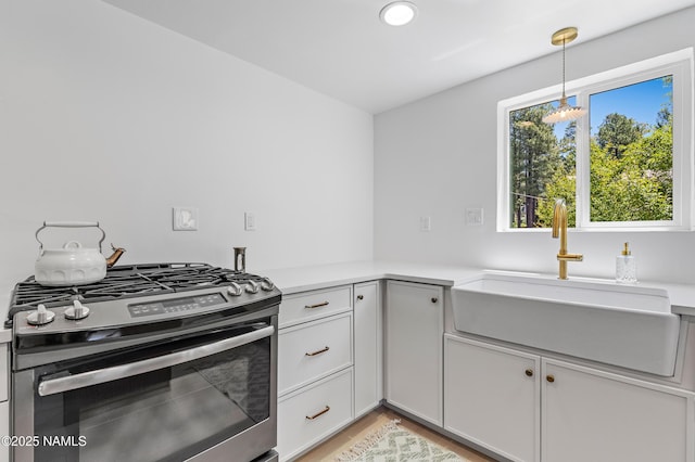535 Stringer Rd, Munds Park, AZ 86017 - kitchen featuring stainless steel gas range oven, light countertops, light wood-style flooring, hanging light fixtures, and recessed lighting