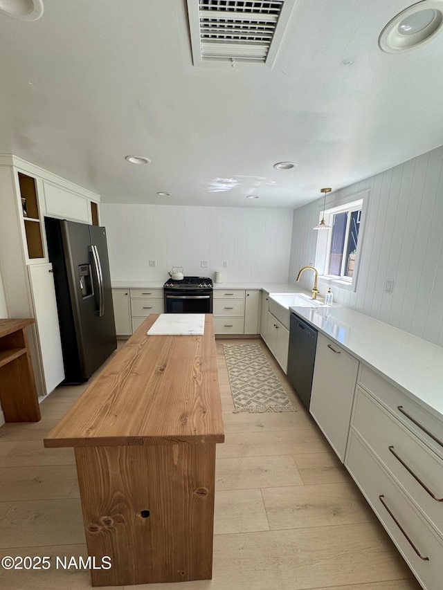 535 Stringer Rd, Munds Park, AZ 86017 - kitchen with stainless steel appliances, wood counters, light wood-type flooring, a center island, and hanging light fixtures