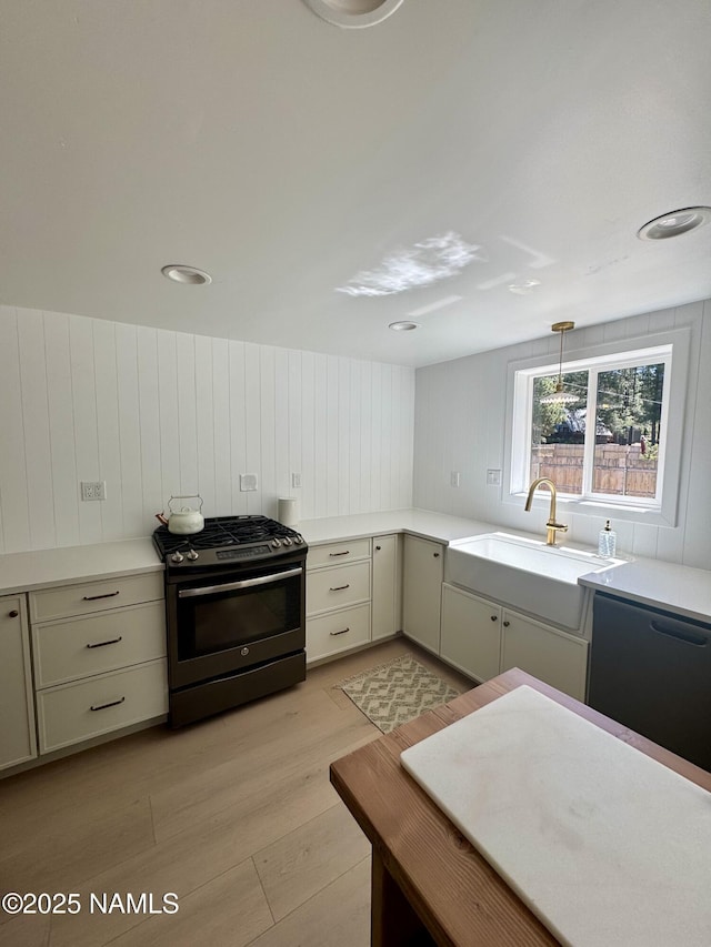 535 Stringer Rd, Munds Park, AZ 86017 - kitchen with gas stove, light wood-type flooring, light countertops, dishwasher, and wooden walls