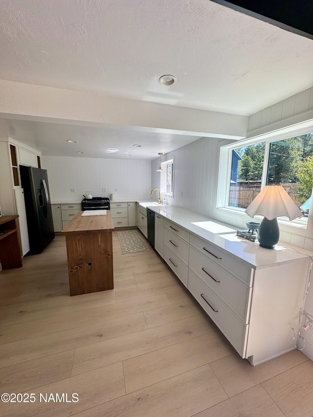 535 Stringer Rd, Munds Park, AZ 86017 - kitchen with black appliances, a kitchen island, wood counters, light wood finished floors, and healthy amount of natural light