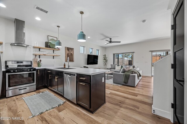 3580 Huron, Flagstaff, AZ 86005 - kitchen featuring wall chimney range hood, appliances with stainless steel finishes, a sink, light countertops, and visible vents
