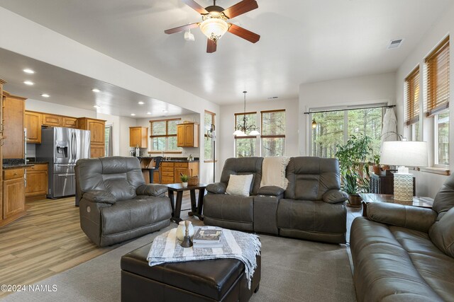 living room featuring light hardwood / wood-style flooring and ceiling fan