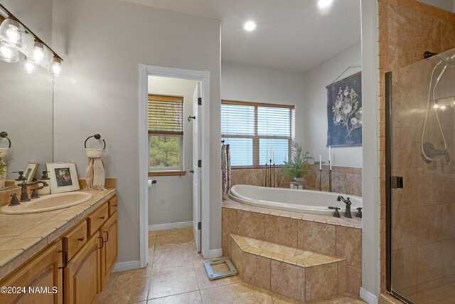 bathroom featuring vanity, shower with separate bathtub, and tile patterned flooring