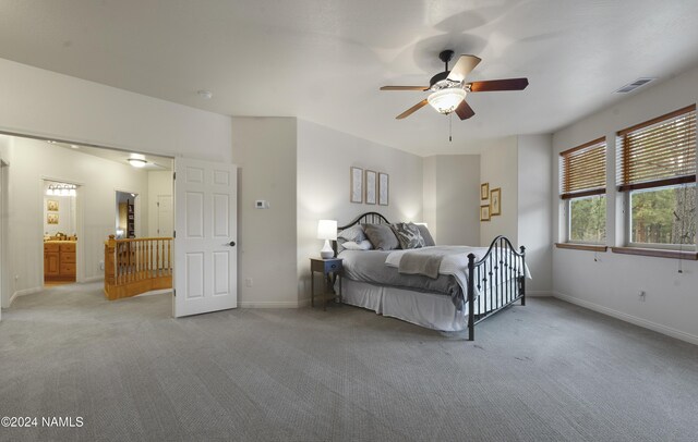 bedroom featuring ceiling fan, light carpet, and ensuite bath