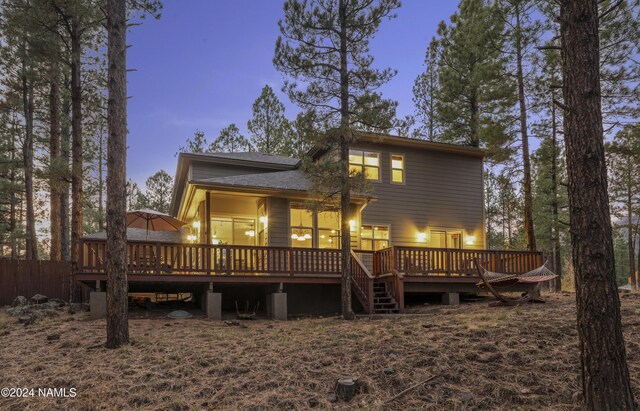 back house at dusk with a wooden deck