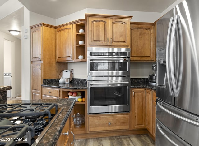 kitchen with hardwood / wood-style floors, dark stone countertops, and appliances with stainless steel finishes