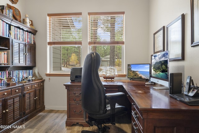 home office with light hardwood / wood-style floors