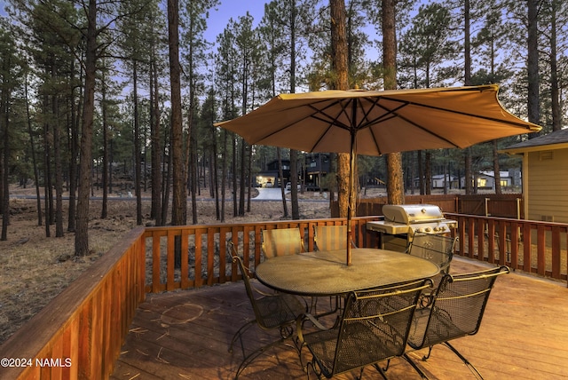 deck at dusk featuring grilling area