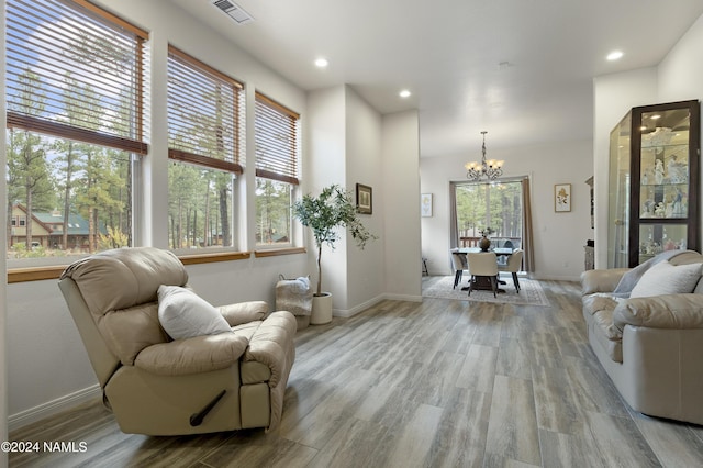 living room featuring a chandelier and light hardwood / wood-style flooring