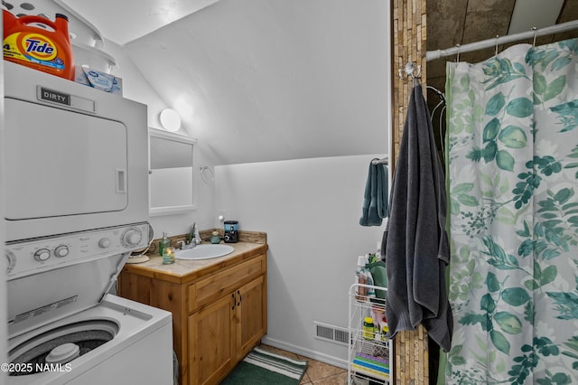 7507 Deville Ln, Flagstaff, AZ 86004 - full bath with stacked washing machine and dryer, lofted ceiling, vanity, tile patterned floors, and a shower with curtain