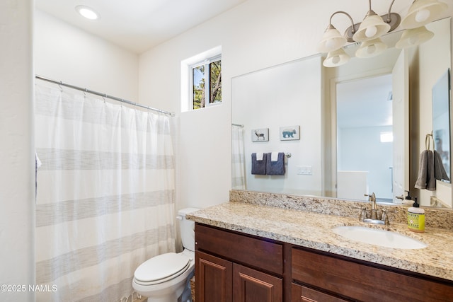 bathroom featuring vanity, a notable chandelier, and toilet