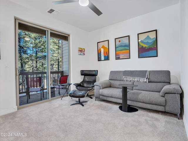 carpeted living room with ceiling fan