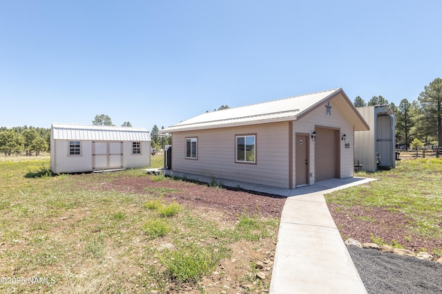 3095 E Pinetree Dr, Williams, AZ 86046 - view of front of home with a garage, a storage shed, a metal roof, and a front yard