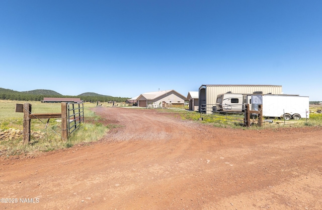 3095 E Pinetree Dr, Williams, AZ 86046 - view of dirt / gravel road with a gated entry, a rural view, and a mountain view