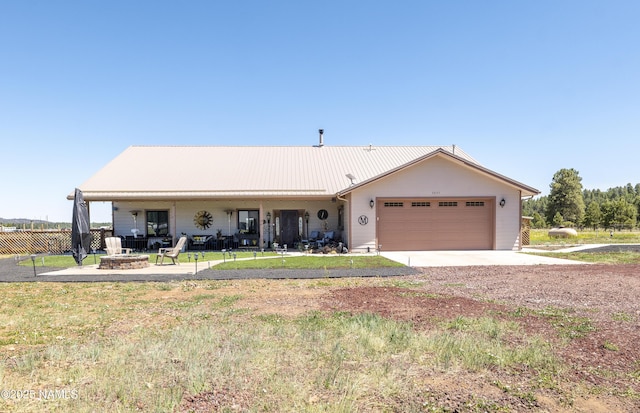 3095 E Pinetree Dr, Williams, AZ 86046 - ranch-style home with a garage, driveway, a fire pit, and a metal roof