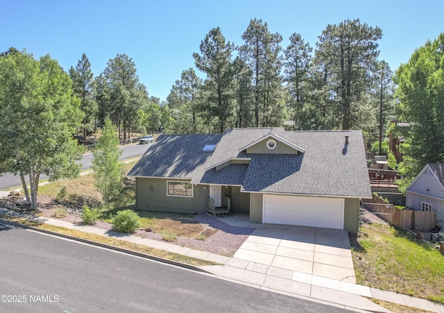 1470 W Melissa Dr, Flagstaff, AZ 86005 - view of front of home featuring a shingled roof, driveway, an attached garage, and view of wooded area