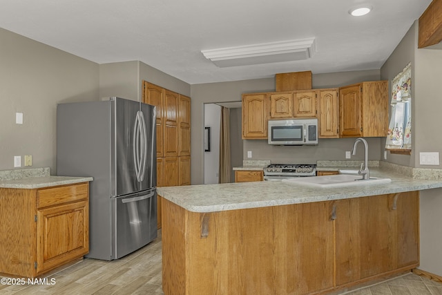 1470 W Melissa Dr, Flagstaff, AZ 86005 - kitchen with stainless steel appliances, a peninsula, light countertops, light wood finished floors, and brown cabinetry