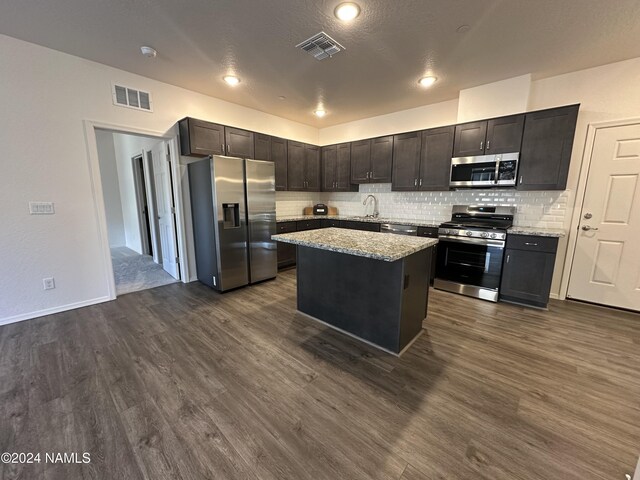 kitchen featuring a kitchen island, sink, dark hardwood / wood-style floors, and stainless steel appliances