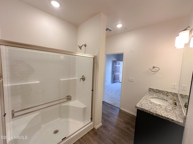 bathroom featuring vanity, an enclosed shower, and wood-type flooring