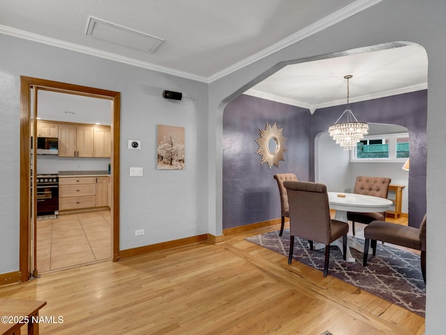 dining area with light wood-style floors and crown molding