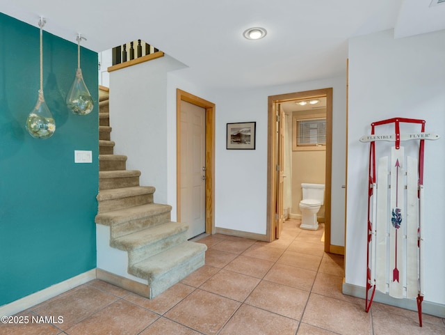 stairs featuring tile patterned floors and baseboards