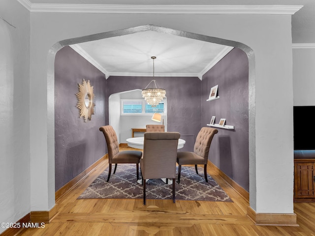 dining space with crown molding, parquet floors, arched walkways, and a chandelier