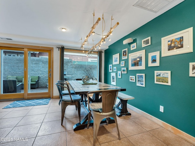 dining space featuring tile patterned floors, visible vents, a chandelier, and baseboards