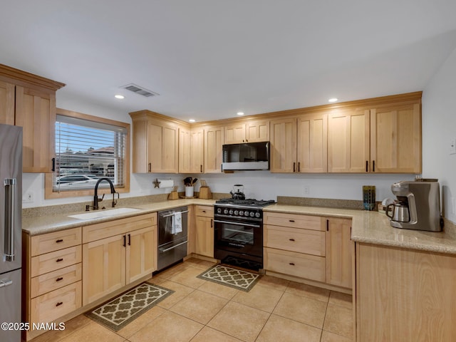 kitchen with visible vents, light brown cabinets, premium appliances, and a sink