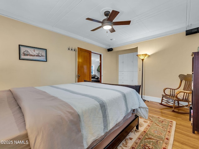 bedroom featuring a ceiling fan, baseboards, and light wood finished floors