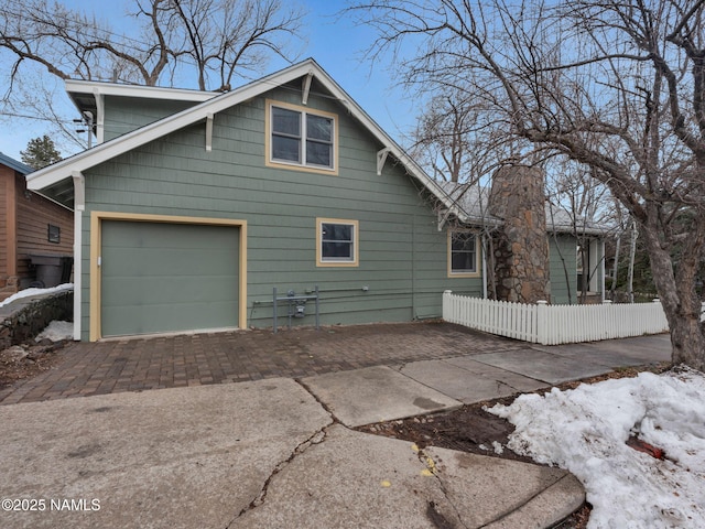 view of property exterior with fence and driveway