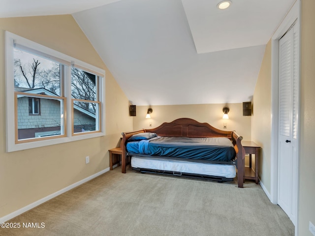 bedroom with lofted ceiling, carpet, and baseboards