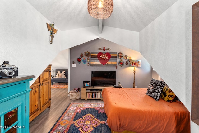 bedroom with a textured ceiling, light wood-type flooring, and vaulted ceiling with beams