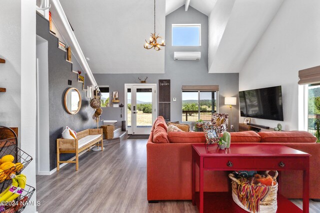 living room with an AC wall unit, a healthy amount of sunlight, hardwood / wood-style flooring, and a high ceiling