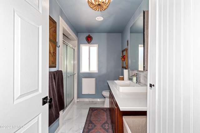 bathroom with toilet, a shower with shower door, and vanity