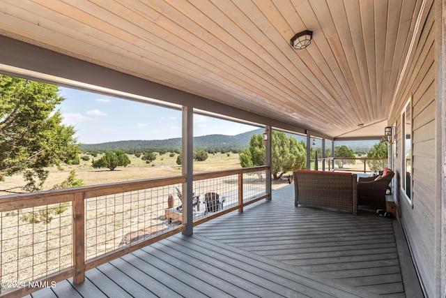 wooden terrace featuring a mountain view, a rural view, and an outdoor hangout area