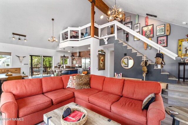 living room featuring high vaulted ceiling, wood-type flooring, and a notable chandelier