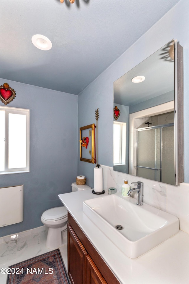 bathroom featuring vanity, radiator heating unit, plenty of natural light, and a shower with door