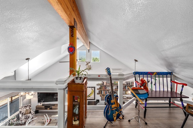 interior space with hardwood / wood-style flooring, a textured ceiling, and beamed ceiling