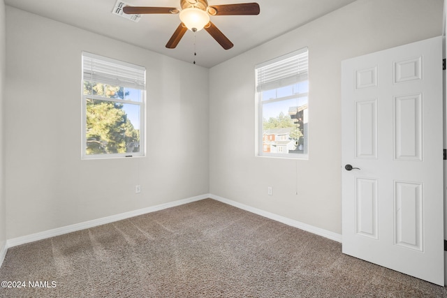 unfurnished room with carpet floors, a wealth of natural light, and ceiling fan