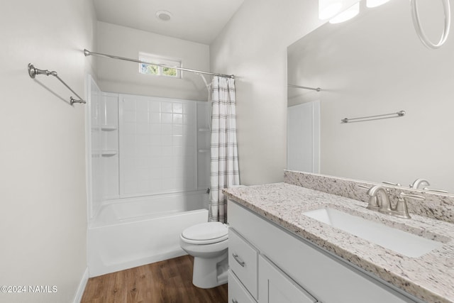 full bathroom featuring vanity, hardwood / wood-style flooring, shower / tub combo, and toilet