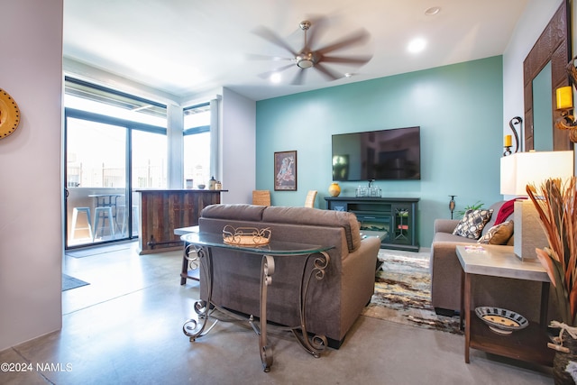 living room with ceiling fan and expansive windows