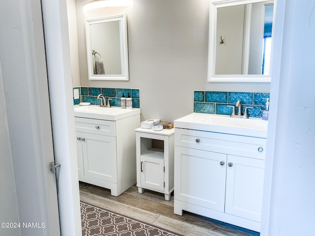 bathroom with hardwood / wood-style flooring, decorative backsplash, and vanity