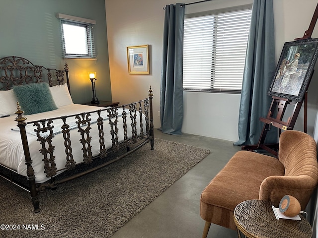 bedroom featuring concrete floors and multiple windows