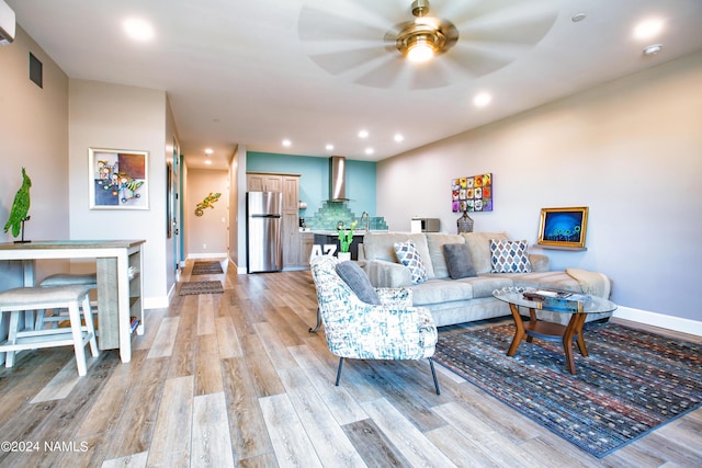 living room with ceiling fan and light wood-type flooring