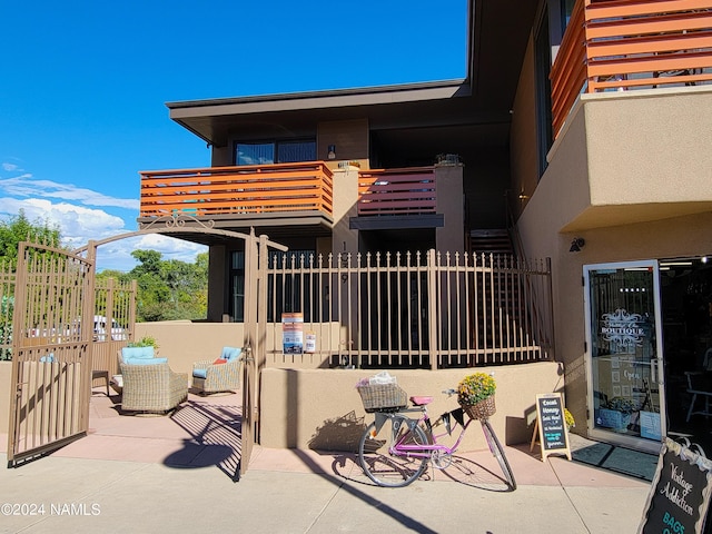 rear view of property featuring a balcony and a patio area