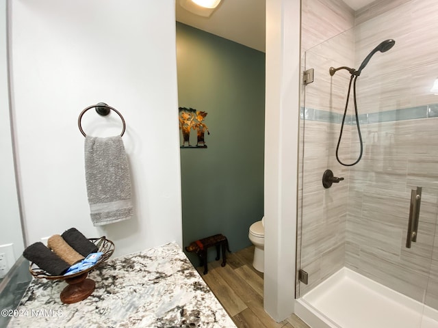 bathroom featuring toilet, walk in shower, and wood-type flooring